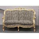 A Rococo style two seat parlour settee with leopard skin effect upholstery.