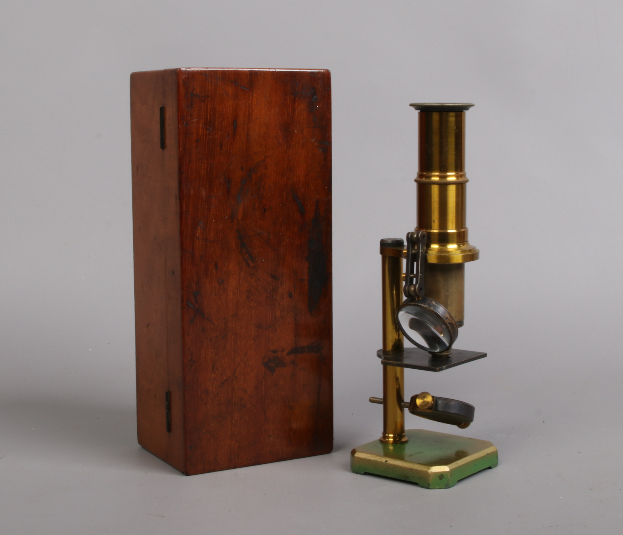 An early 20th century lacquered brass field microscope in mahogany case. Condition report intended
