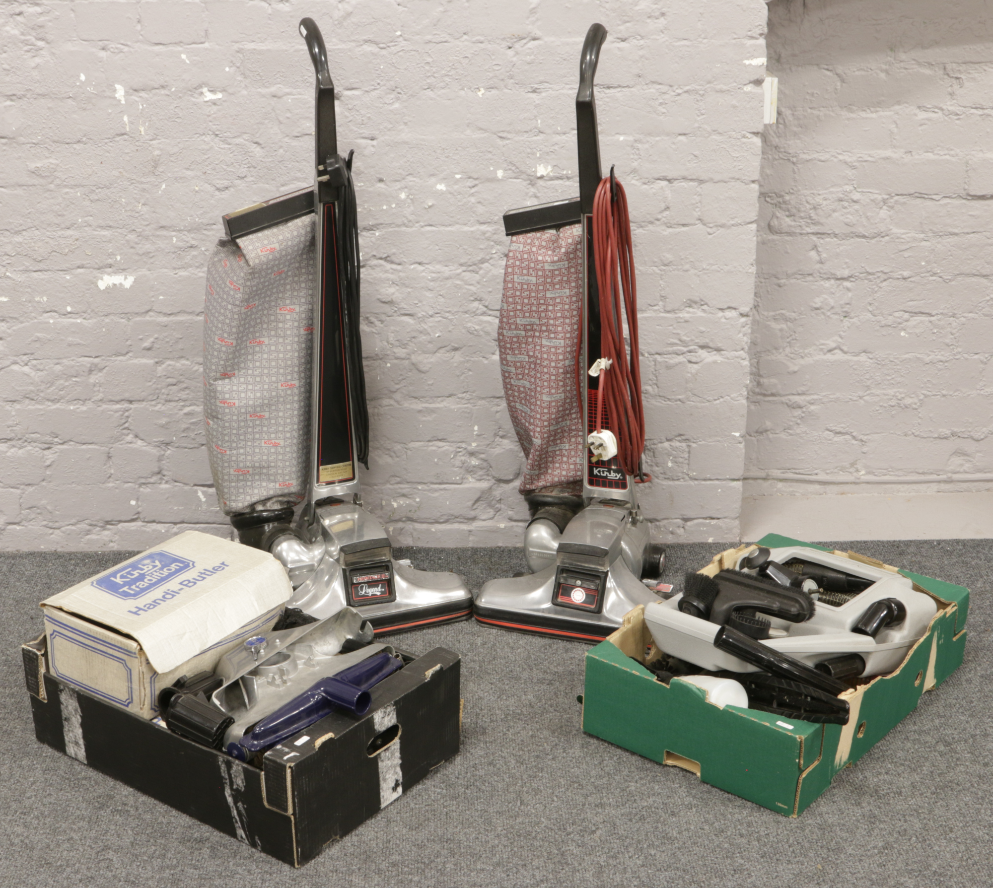 Two Kirby Heritage II vacuum cleaners and two boxes of associated accessories.