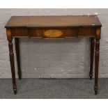 An inlaid mahogany single drawer side table raised on carved and reeded legs.