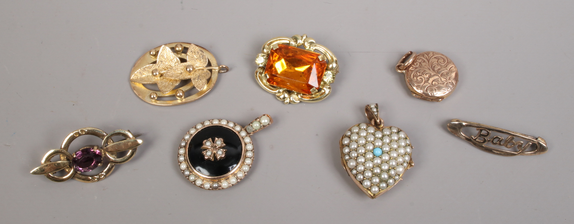 A quantity of yellow metal jewellery including coloured stone set brooches a heart shaped locket