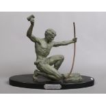 A French Art Deco verdigris spelter figure on oval slate plinth. Formed as a kneeling man dressed in