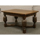 A carved oak draw leaf table with bulbous pineapple supports.