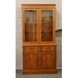 A walnut veneer display cabinet over cupboard base.