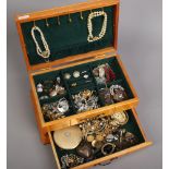 A jewellery box with contents of costume jewellery to include rings, necklaces, earrings, brooches