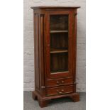 A mahogany glass front bookcase over two drawer base.