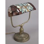 A Tiffany style reading lamp with brush brass effect base.