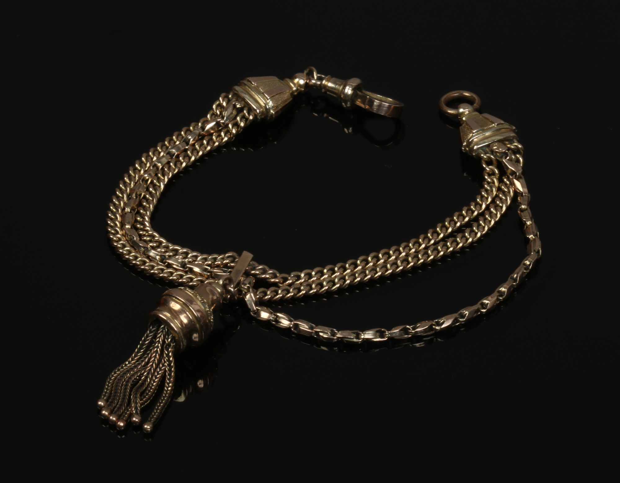A 9ct gold fob watch chain. With three chains, slider and tassel. Stamped 9ct, 17.8 grams.