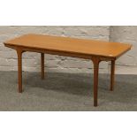 A McIntosh teak coffee table with sliding leaves to each end, L 106.5cm x W 48cm x H 47cm.