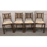 A set of four oak dining chairs with floral upholstery raised on square cut supports.