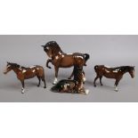 Three Beswick horses along with a recumbent similar example.Condition report intended as a guide