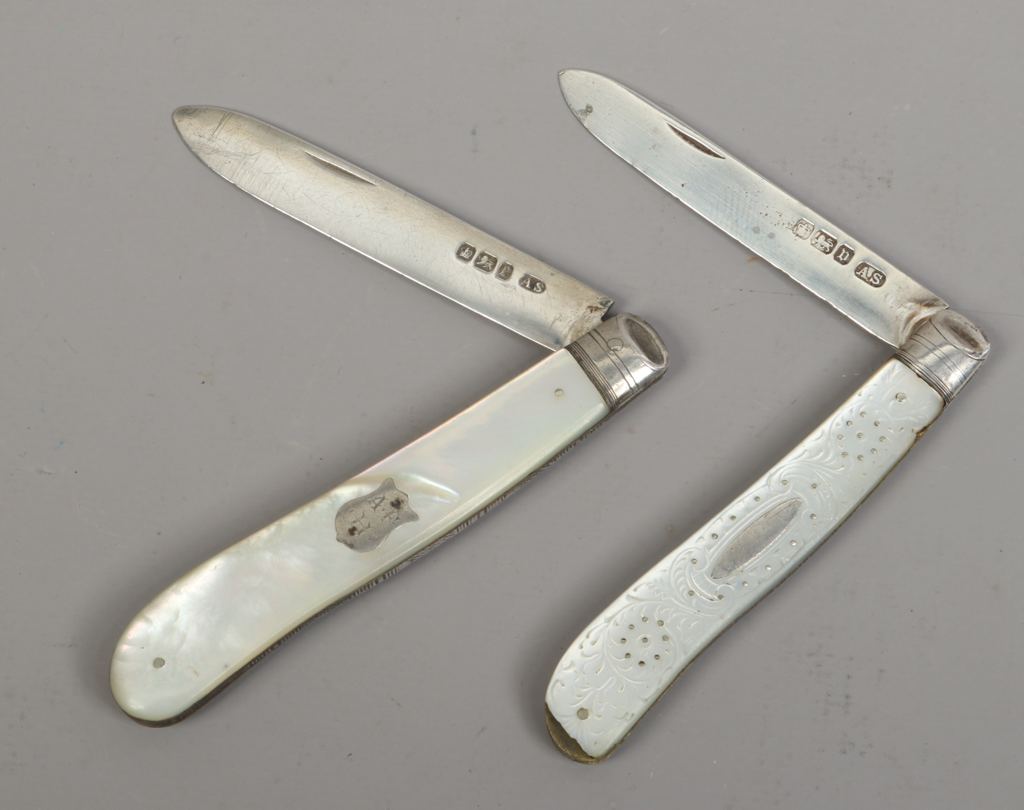 Two silver folding fruit knives with mother of pearl scales, assayed Sheffield 1897 and 1913.