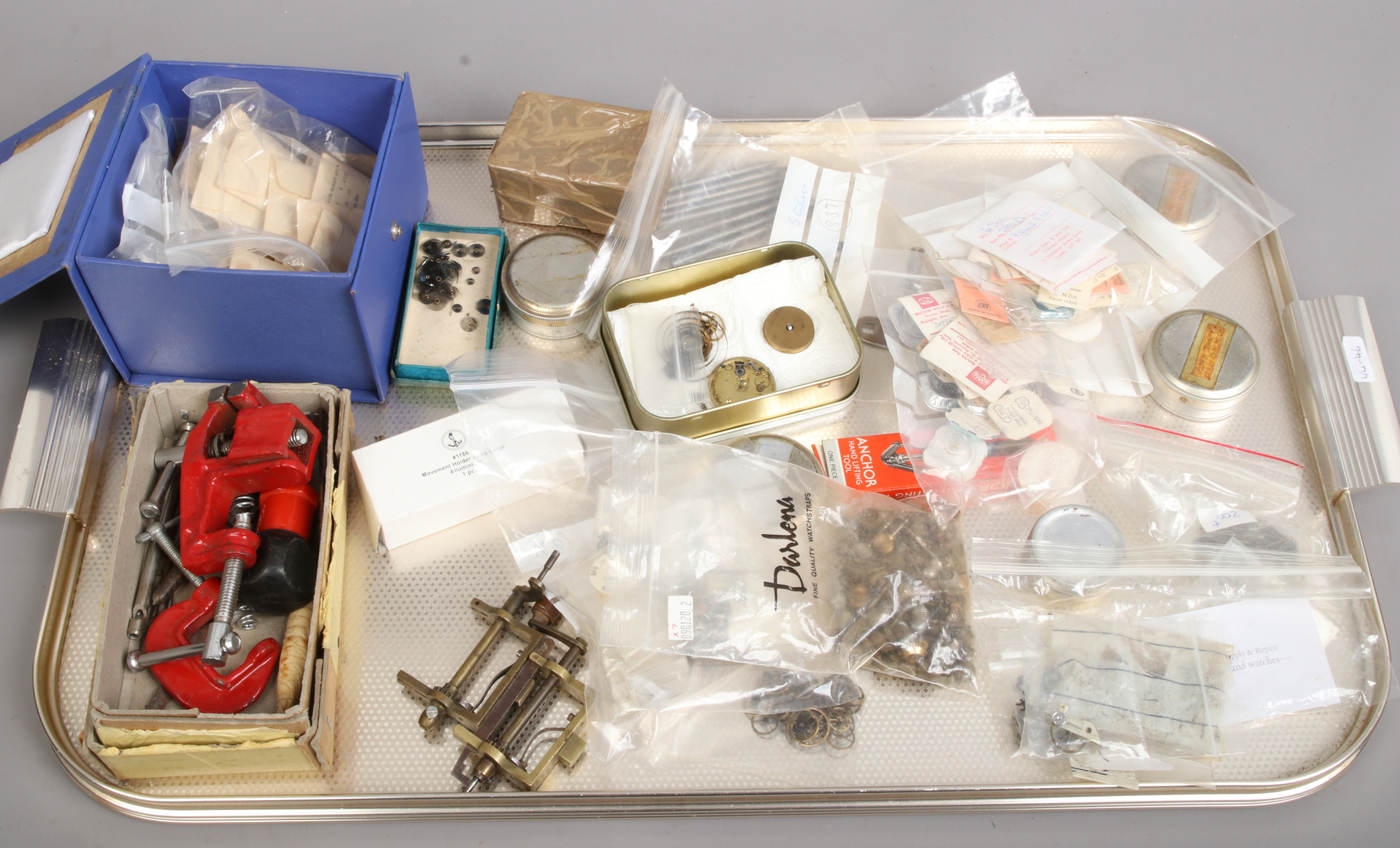A tray of watch repairers spare parts including balance wheels etc.
