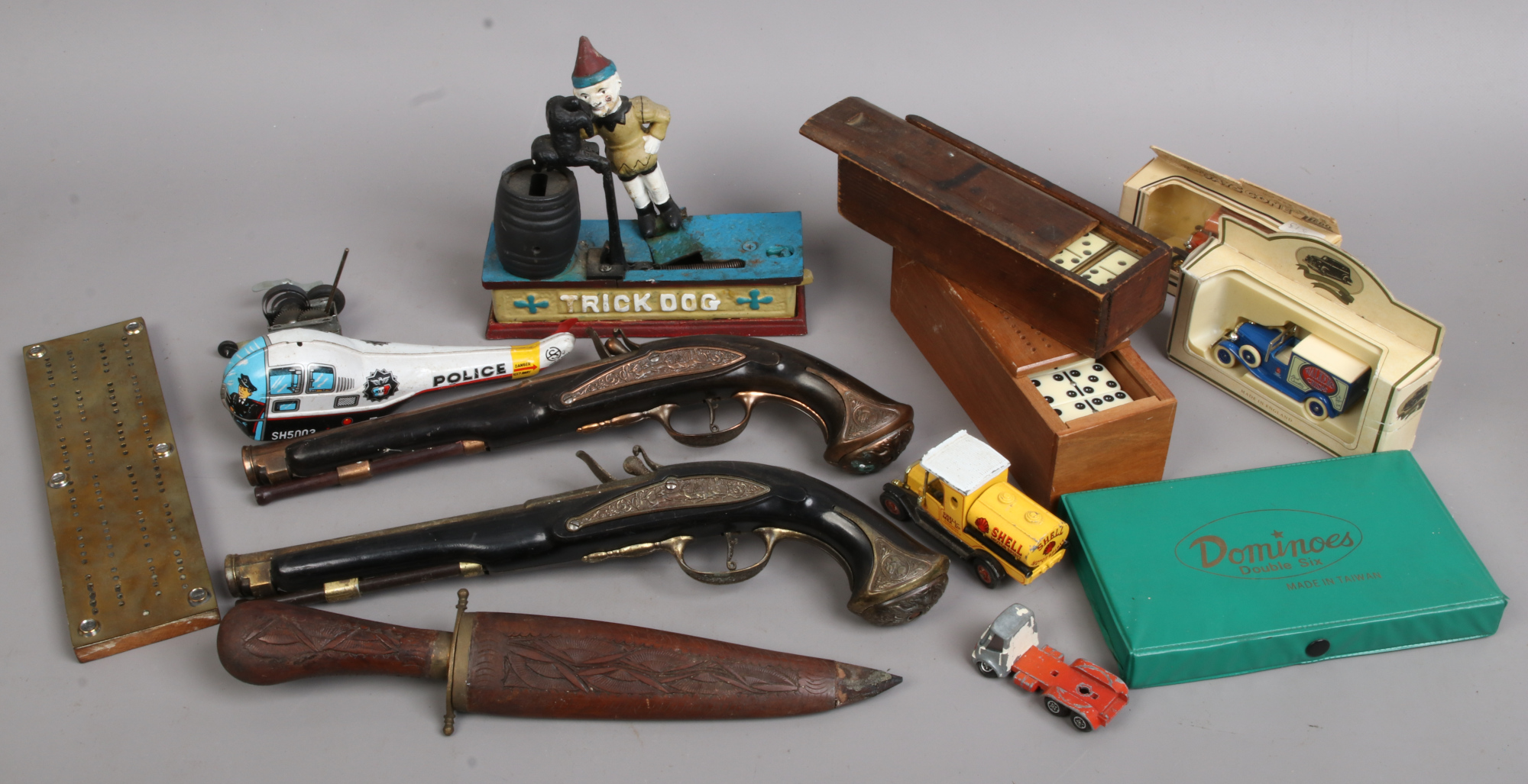 A box of collectables to include dagger in sheath, two pistols, dominoes sets, toys etc.