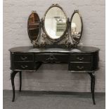A painted black dressing table of kidney shape with gilt decoration raised on cabriole supports.