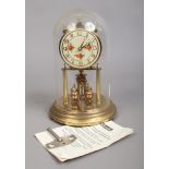 A brass 400 day anniversary clock, maker Kundo, Germany. Under glass dome and with a key.