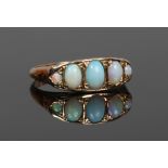 A 9ct gold and five stone opal ring with boat shaped setting and scroll work engraving, size M1/2.