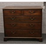 A Georgian mahogany chest of two over three graduated drawers raised on bracket feet.