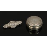 A cased silver commemorative brooch and a French silver pill box with engine turned engraving.