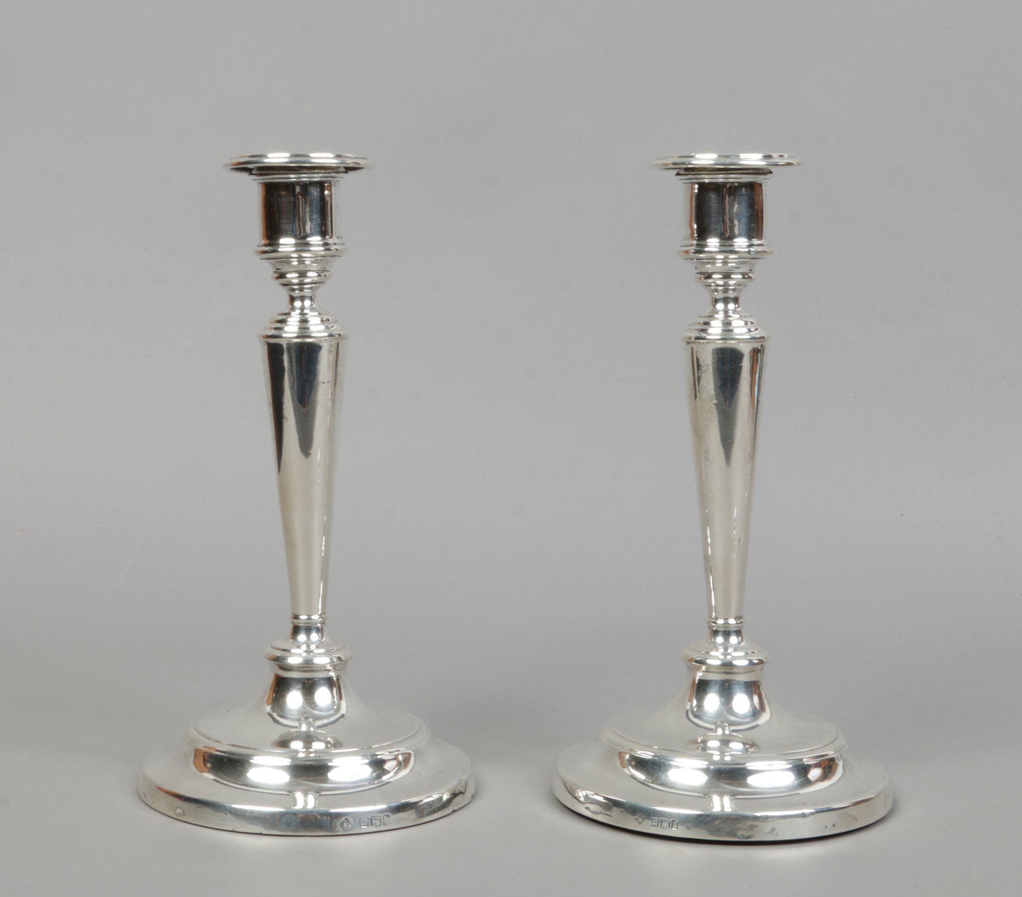 A matched pair of Edwardian silver weighted table candlesticks with detachable nozzles by Martin