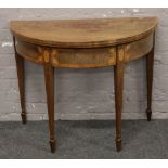 A 19th century mahogany demi lune fold over card table on tapered legs.