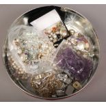 A tin of costume jewellery to include yellow metal examples, clip on earrings, simulated pearls