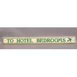 A painted wooden hotel sign 'To Hotel Bedrooms'.