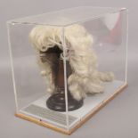 A cased Victorian horses hair ladies theatrical wig on turned wood wig stand.