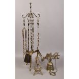 A gilt metal fireside companion set, along with a decorative brass wall mounting bell and a gilt