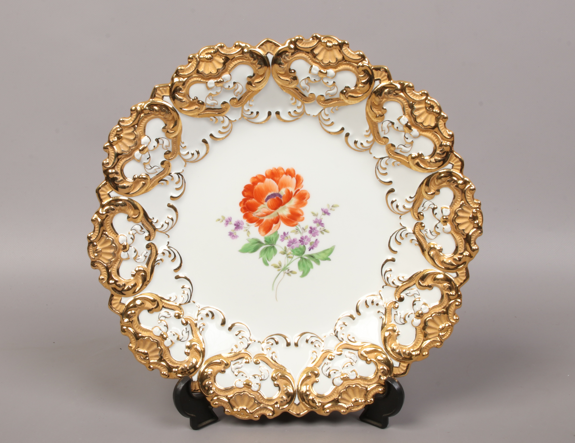 A Meissen dish with gilded shell border and hand painted with flowers, crossed swords mark to the