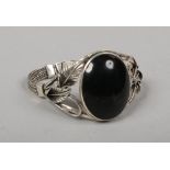 A silver bangle set with a large ovoid onyx tablet.