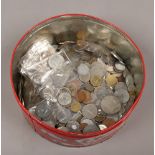 A tin of various foreign and British coins.