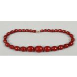 A string of graduated cherry amber coloured Bakelite beads, L 39cm weight 34 grams.