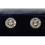 A pair of silver and diamond cluster earrings.
