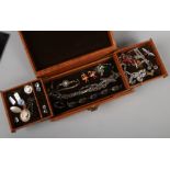 A tan leather jewellery box containing silver and metal costume jewellery oddments including cameo