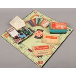 A 1940s edition of Monopoly with wooden buildings and players markers, along with a selection of