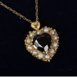 A cased 9ct gold garnet and pearl heart shaped pendant on chain.