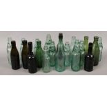 A collection of twenty clear and coloured glass brewery advertising bottles to include cod bottles.