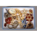 A tray of 1950s and later costume jewellery brooches.