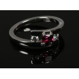 A platinum ruby and diamond three stone cross over ring size P.