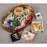 A tin of costume jewellery to include silver examples.