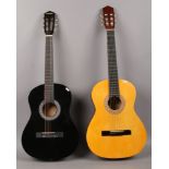 A Stagg handmade classic guitar model No. C542 along with a black acoustic guitar in carry bag.