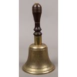 A brass bell with turned wooden handle.