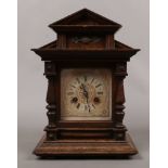 A German carved oak Junghans mantel clock with twin train movement, chiming on a coiled gong.