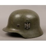 A German steel WWII Third Reich combat helmet. With national eagle and tri colour flag decals, the