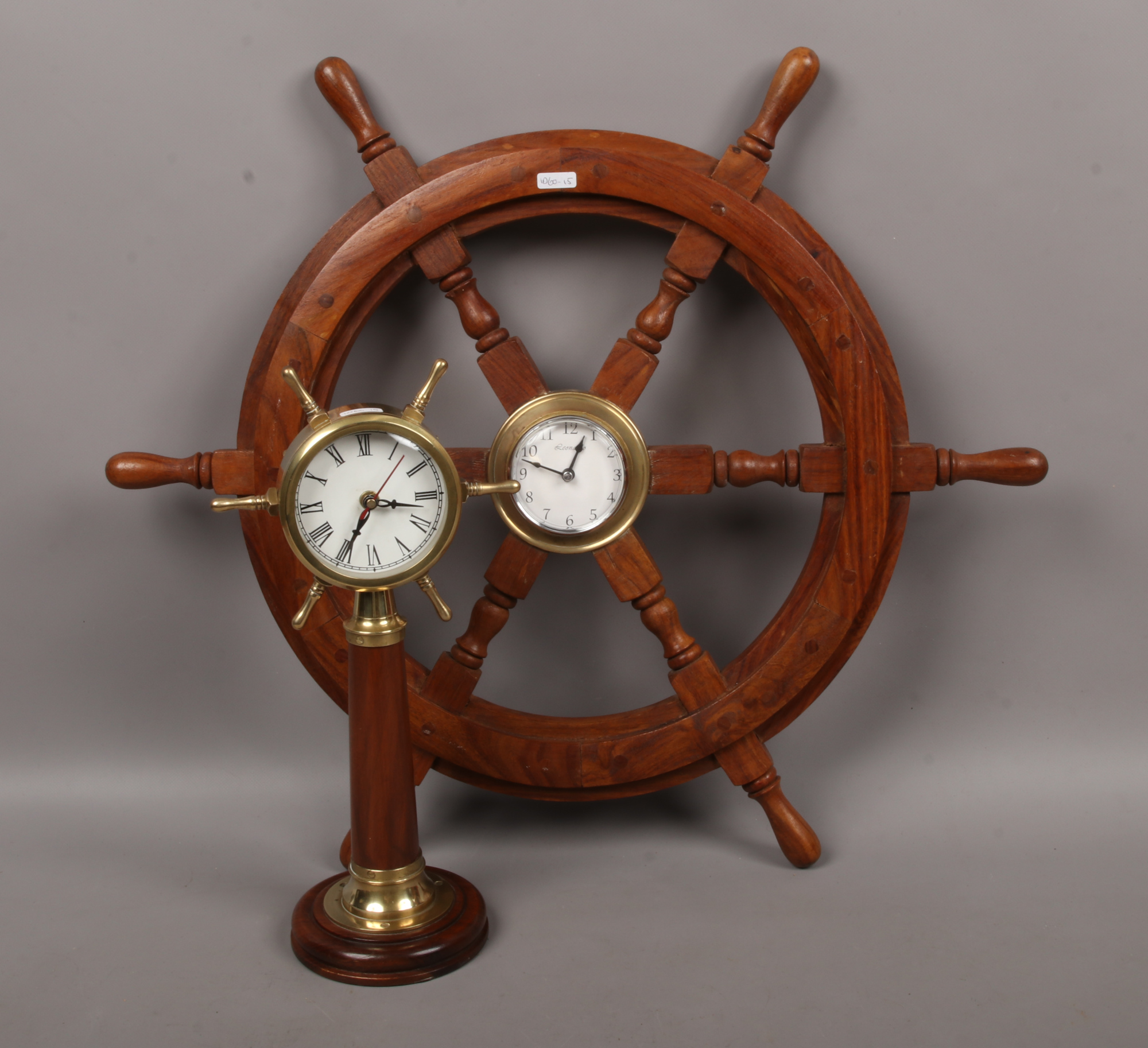 A ships wheel with brass centre boss housing a Leonardo quartz clock, along with similar clock.