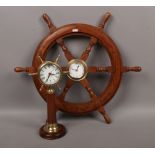 A ships wheel with brass centre boss housing a Leonardo quartz clock, along with similar clock.