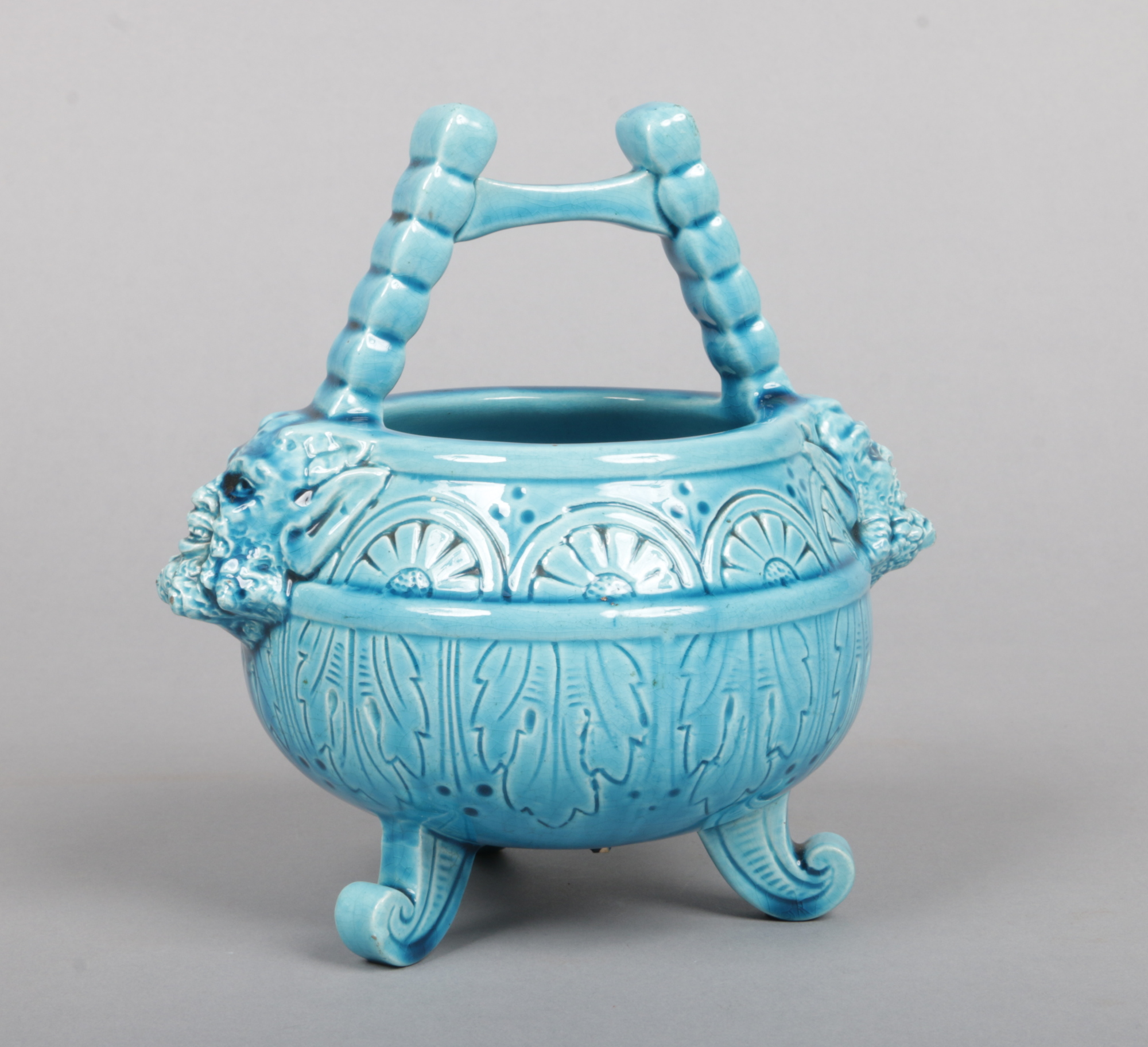 A Burmantofts Faience small planter formed as a cauldron. With twin satyr mask handles, incised