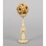 A 19th century Cantonese carved ivory puzzle ball on figural stand, 17cm.Condition report intended