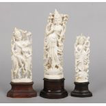 Three early 20th century Indian carved ivory figures of Hindu deities raised on hardwood plinths.